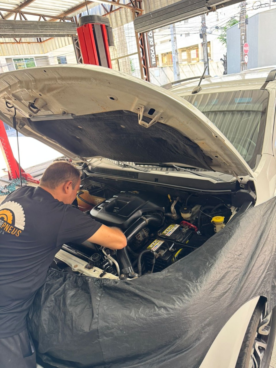 Profissional checando o motor de um veículo